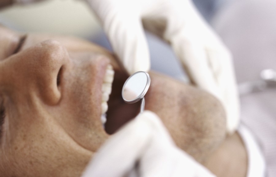 close of dentist examining teeth
